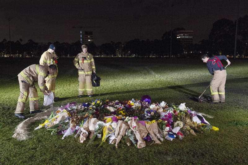 Firefighters clean graffiti painted at the memorial site of murdered Melbourne comedian Eurydice Dixon at Princess Park in Melbourne, Monday, June 18, 2018.