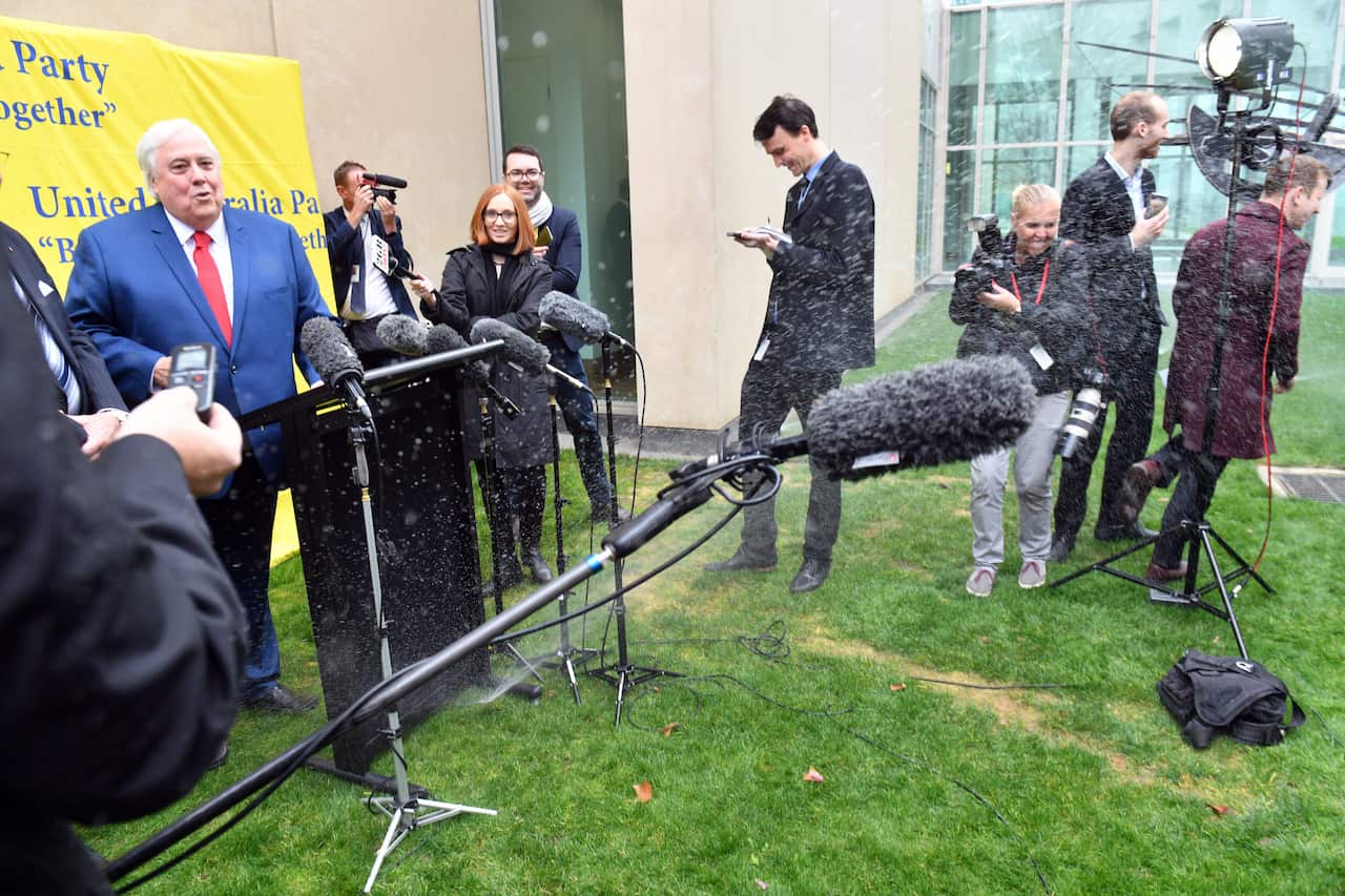 Chaos at Clive Palmer's press conference as sprinklers suddenly turn on