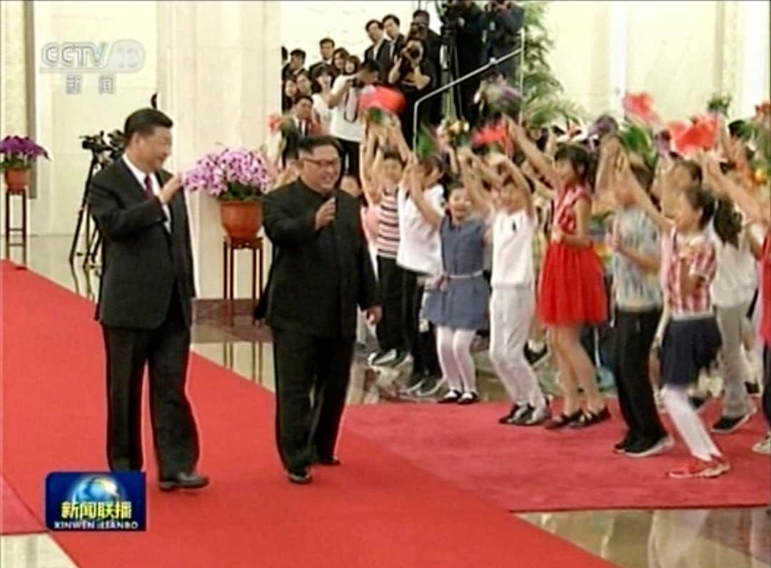 Chinese President Xi Jinping walks with North Korean leader Kim Jong-un at Beijing's the Great Hall of the People.