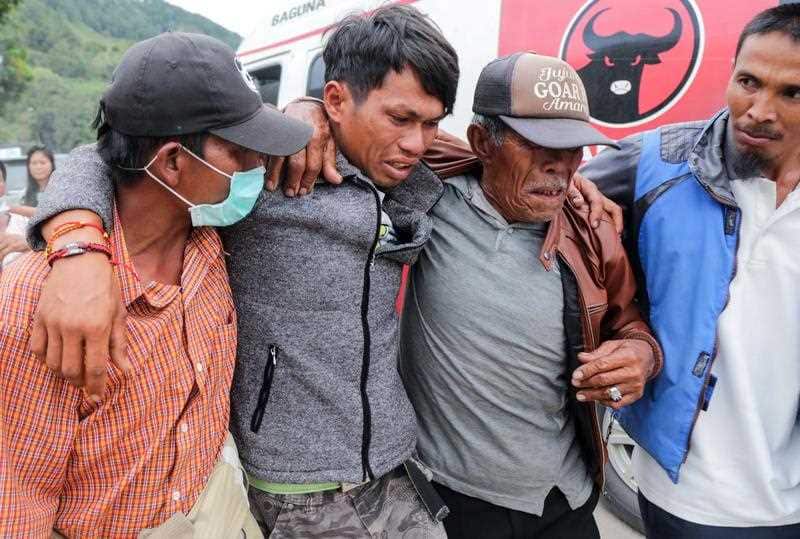 A person, who survived from a boat's sinking in Lake Toba, is helped by relatives shortly after arriving at Tiga Ras port, in North Sumarta, Indonesia, 19 June 2018.