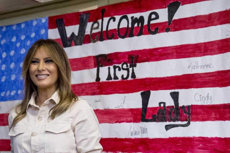First lady Melania Trump smiles after signing American flag artwork while visiting the Upbring New Hope Children Center
