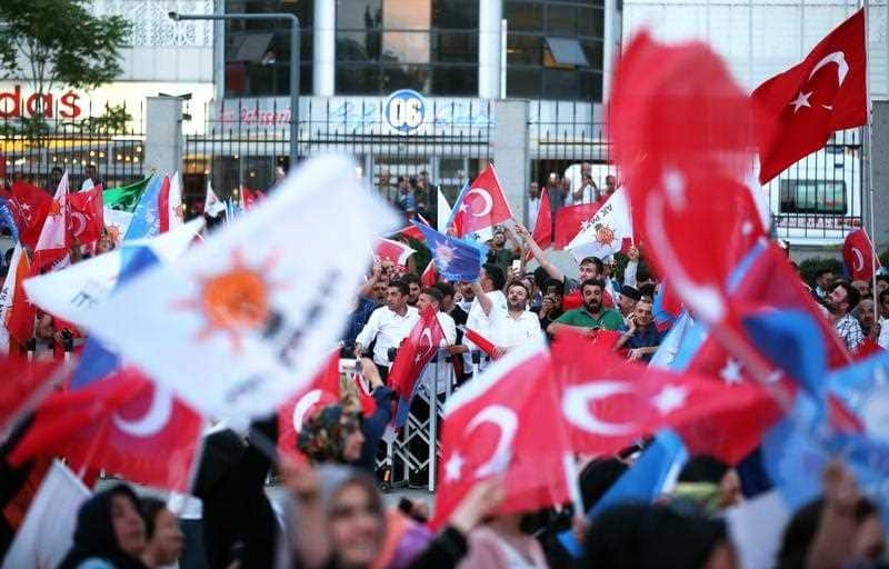 Supporters of Turkish President Erdogan hold Turkish and AK Party flags and greet after closing voting for the Turkish presidential and parliamentary elections in Ankara, Turkey, 24 June 2018. 