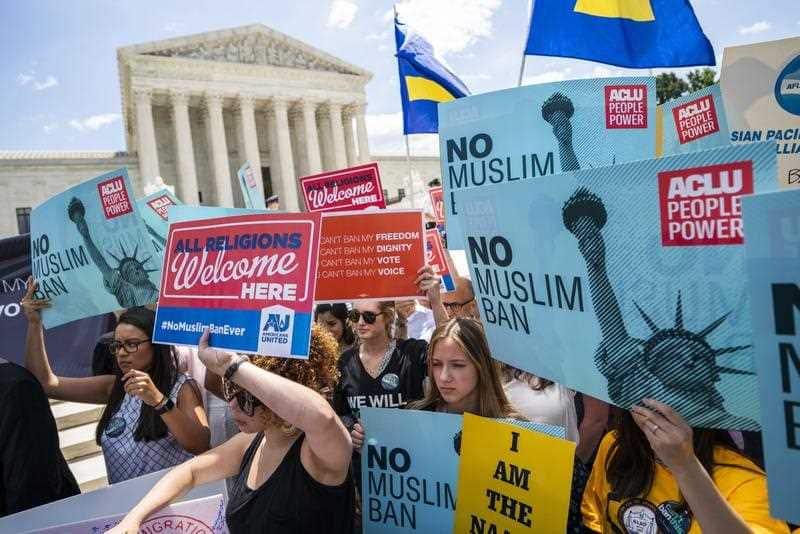 Protesters gather outside the Supreme Court to protest the judge's ruling to uphold President Trump's travel ban in Washington