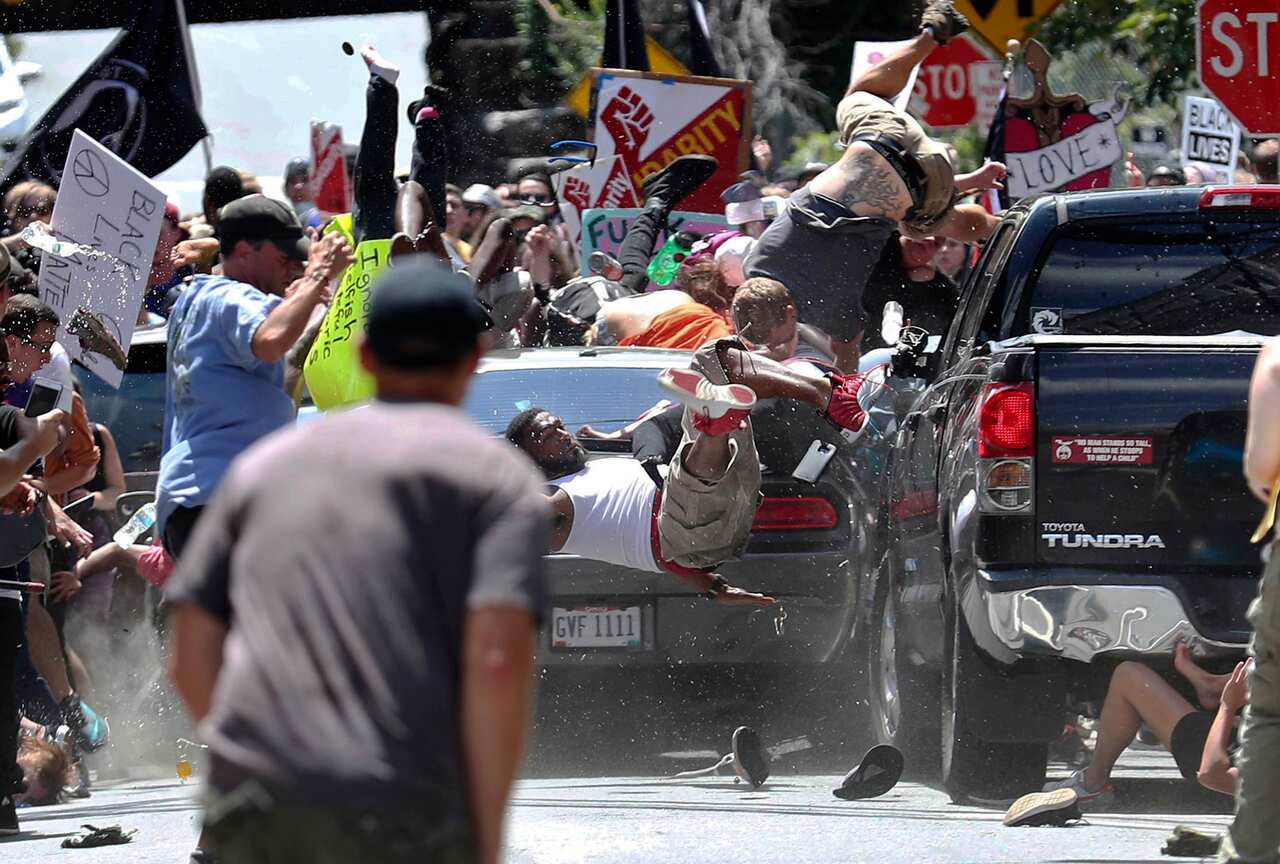 In this Aug. 12, 2017, file photo, people fly into the air as a vehicle is driven into a group of protesters demonstrating against a white nationalist rally in Charlottesville, Va.
