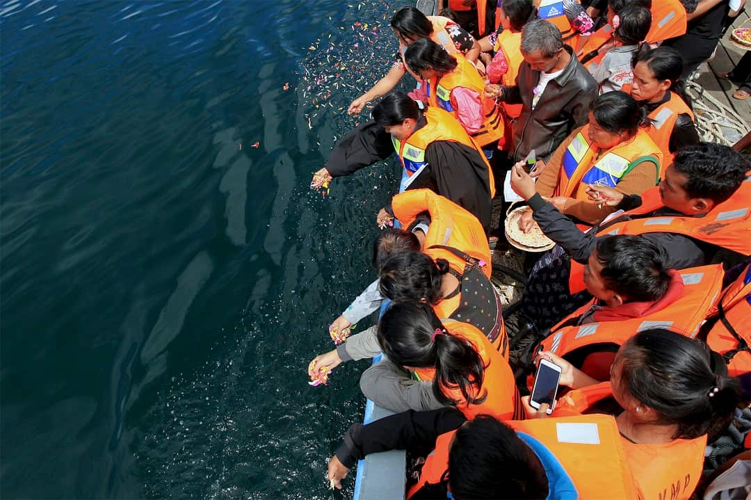 Relatives of the victims scatter flowers into Lake Toba.