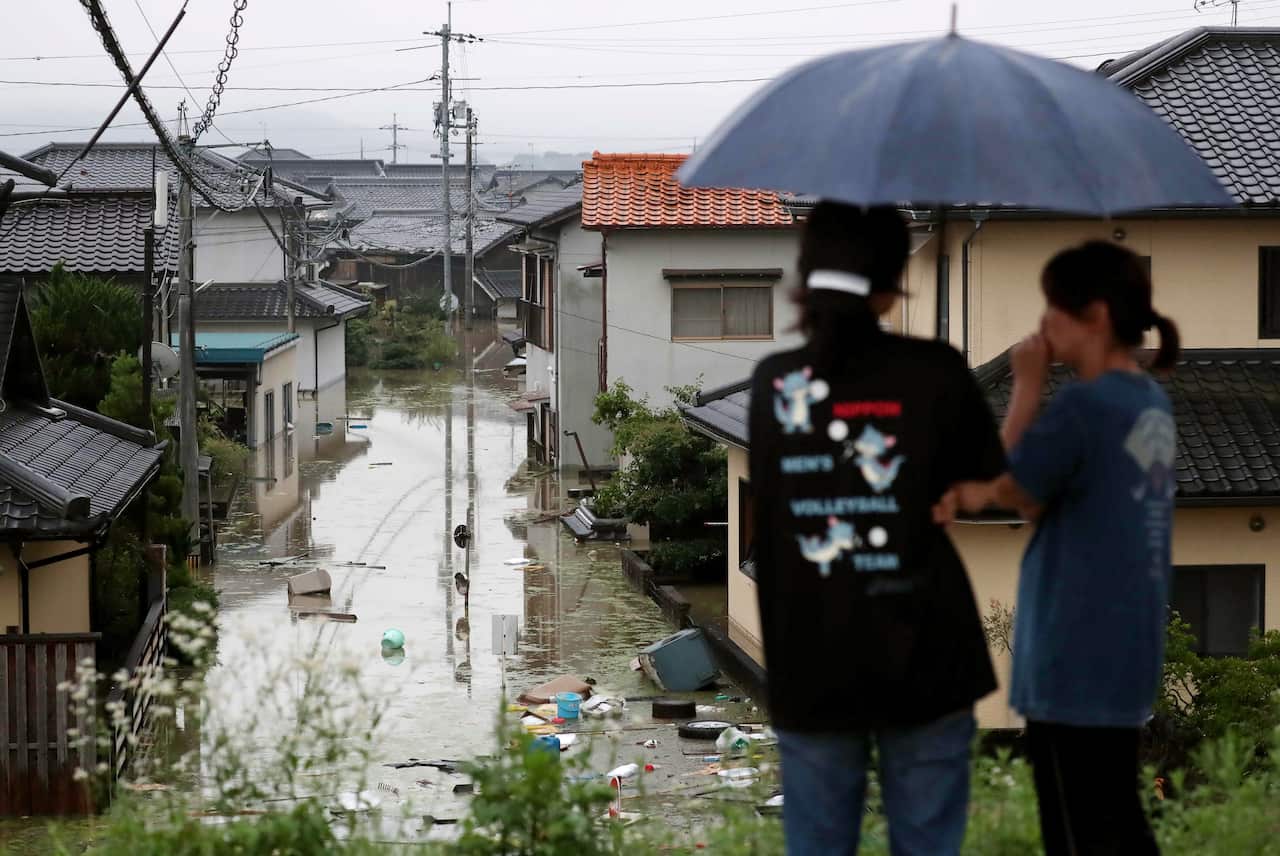 Residents look over their flooded town in Kurashiki, Okayama Prefecture, western Japan.