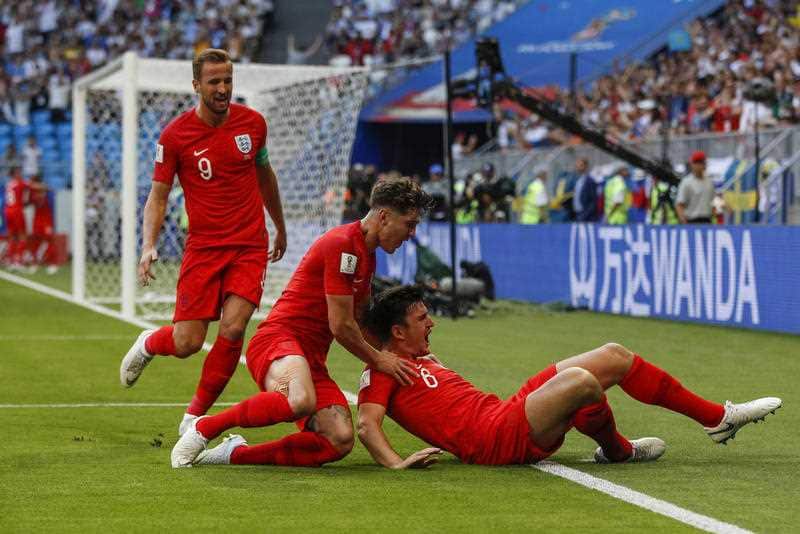 Harry Maguire of England celebrates with John Stones of England and Harry Kane of England after scoring his side's first goal.