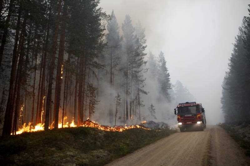 A picture made available on 17 July 2018 shows Firefighters battle wildfires in Karbole outside Ljusdal, Sweden, 15 July 2018 (issued 17 July 2018).