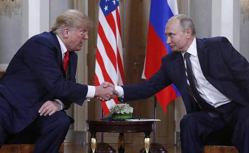 U.S. President Donald Trump, left, and Russian President Vladimir Putin, right, shake hand at the beginning of a meeting at the Presidential Palace in Helsinki.