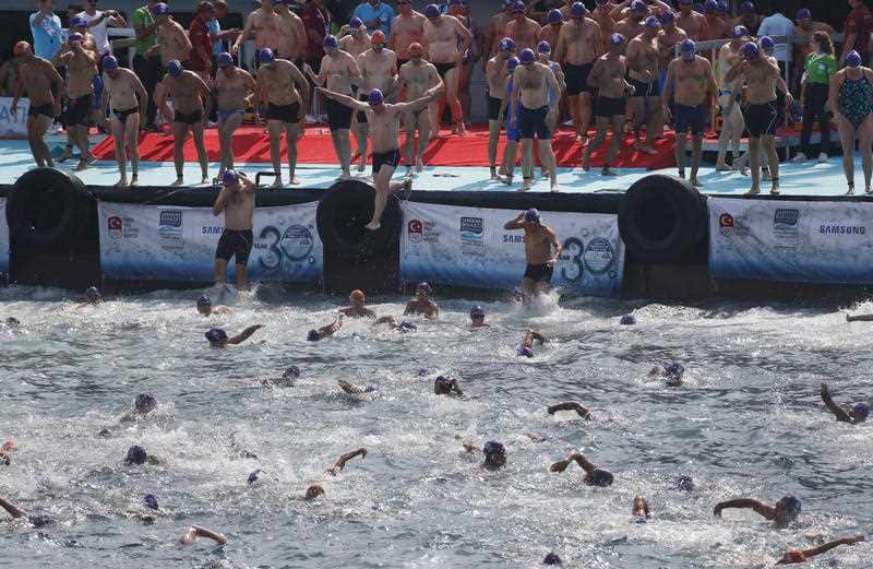 Athletes begin their race from Asia to Europe in the Bosphorus strait during the Bosporus Cross-Continental Swimming Race in Istanbul, Sunday, July 22, 2018.