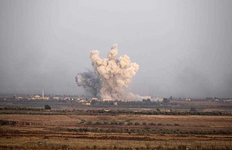 Smoke rises as a result of air strikes on the Syrian side of the Golan Heights at the village of Arab Asudi in the southeastern Quneitra province, as seen from the Israeli side of the border, 25 July 2018.