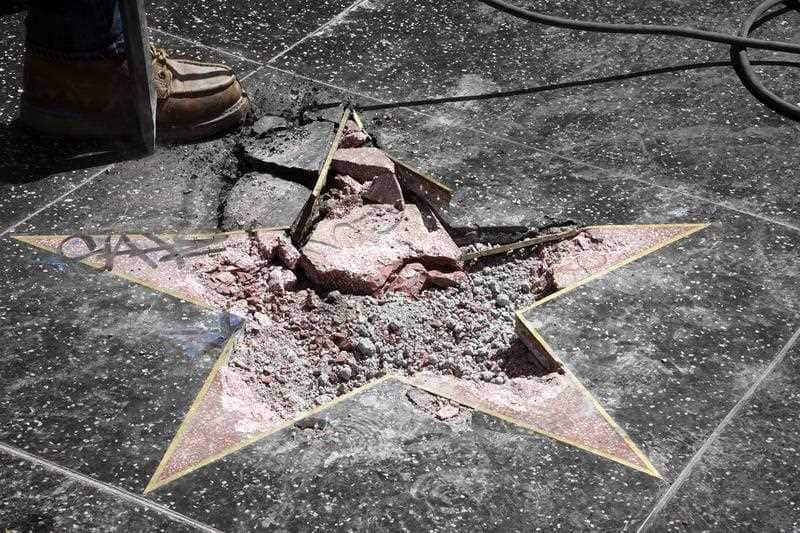 Workers remove the damaged remains of President Donald J. Trump's star on the Hollywood Walk of Fame.