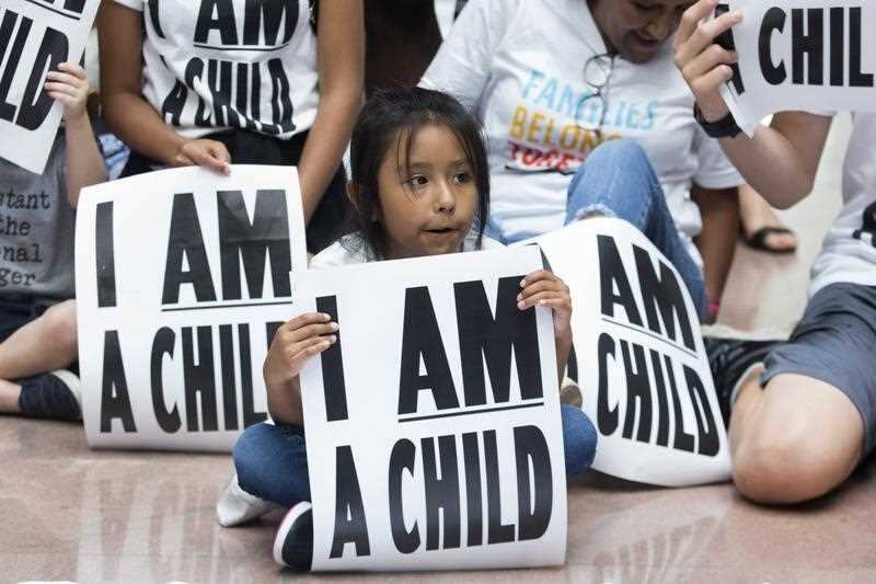 Children and families stage a sit-in to demand the Trump administration reunify migrant families separated at the border.
