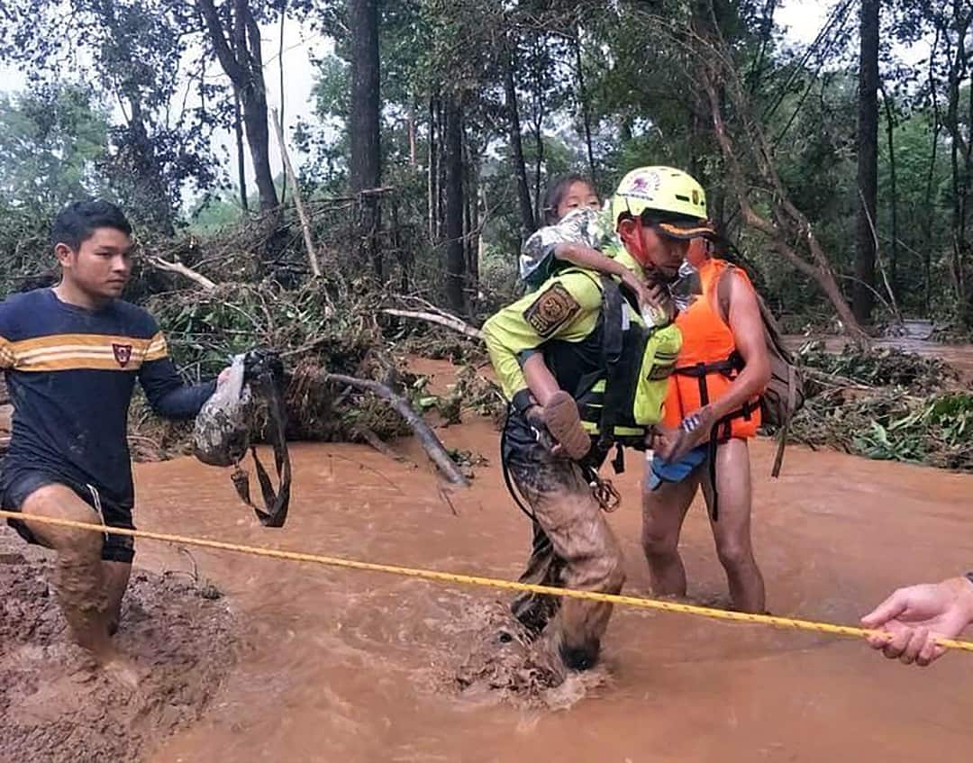 A Lao child is helped by Thai rescuers.