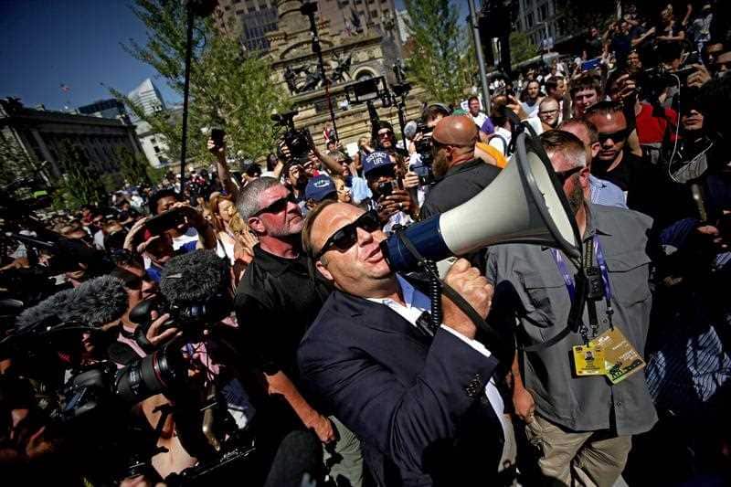 US radio host Alex Jones (C) uses a megaphone to speak to crowds near the Quicken Loans Arena, the venue for the 2016 Republican National Convention.