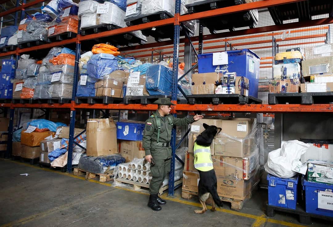 Sombra a drug-sniffing dog sniffs boxes searching for drugs at the cargo hold of El Dorado airport in Bogota, Colombia.