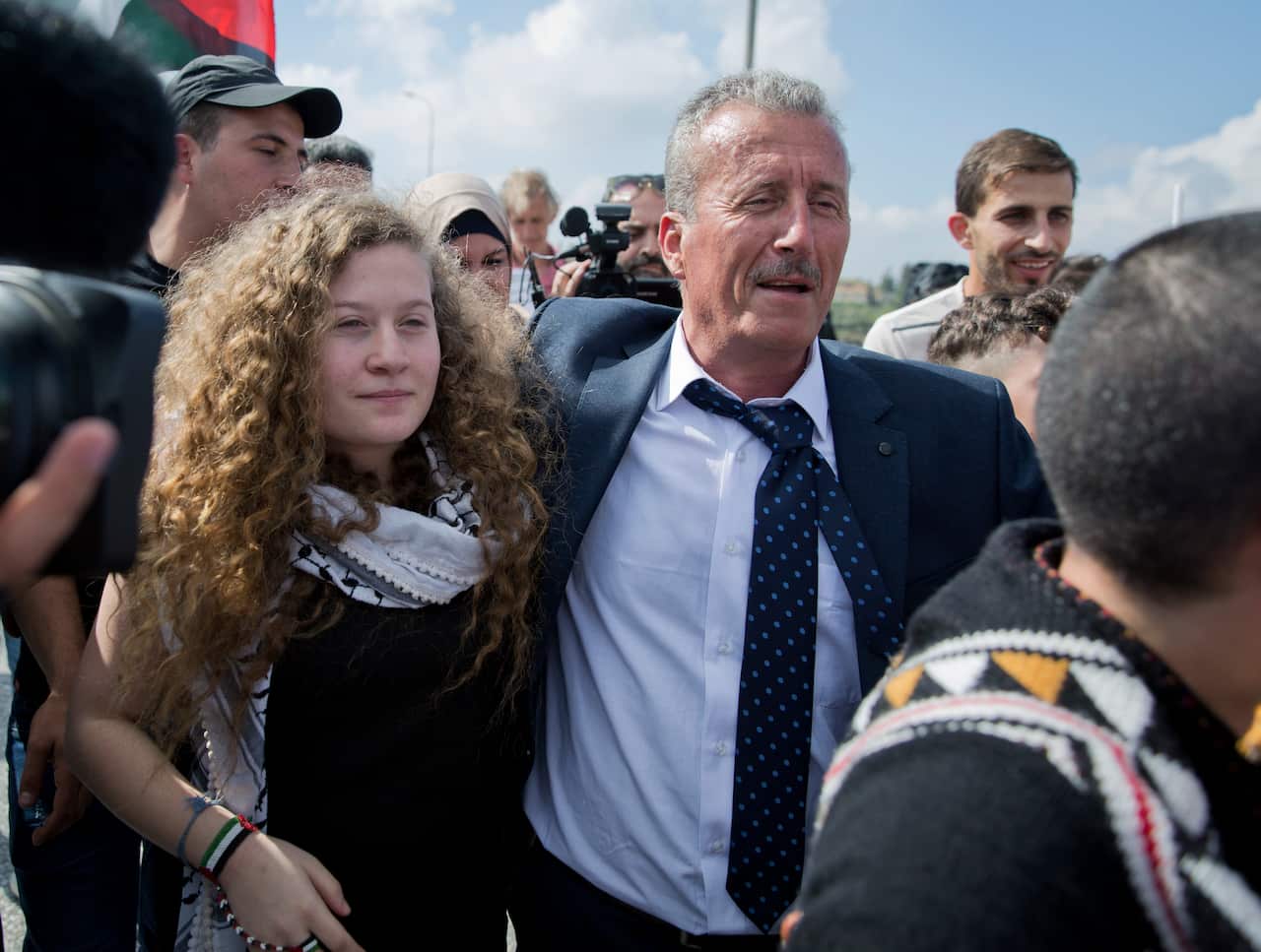 Ahed Tamimi, left walks with with her father Bassem upon her arrival at their West Bank home village of Nebi Saleh, 