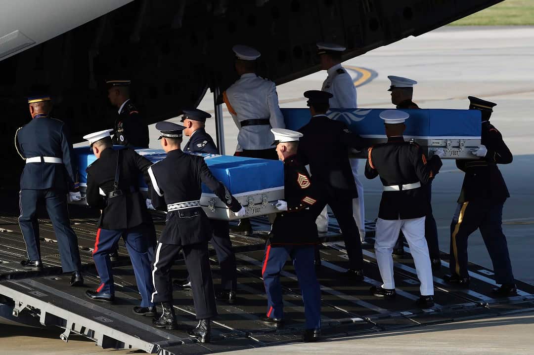 UN honor guards carry a coffin containing the remains of a US soldier who was killed in the Korean War.
