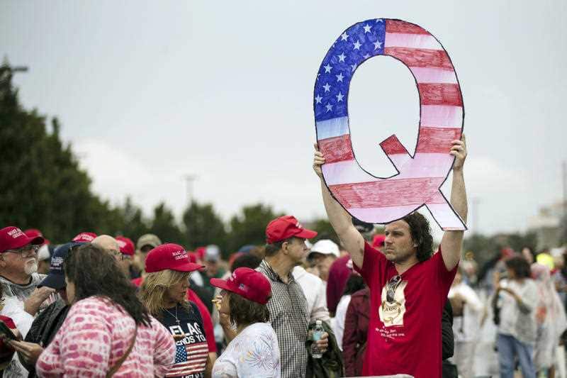 David Reinert holding a Q sign waits in line with others to enter a campaign rally with President Donald Trump and U.S. Senate candidate Rep. Lou Barletta, R-Pa.