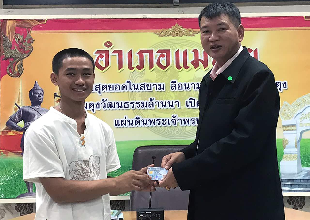 A member of the Wild Boar soccer team Adul Sam-on (L)  as he receives his Thai citizen ID card 