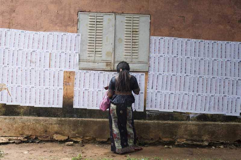 A woman checks for her name outside a polling station before casting her ballot.