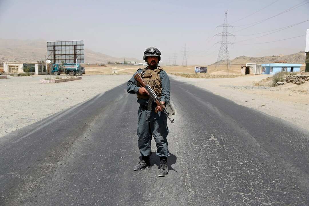 An Afghan Police officer keeps watch at a checkpoint on the Ghazni highway.