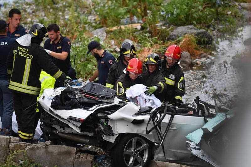 Rescuers work to recover a body after the Morandi highway bridge collapsed in Genoa.