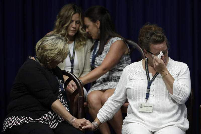 Victims of clergy sexual abuse, or their family members react as Pennsylvania Attorney General Josh Shapiro speaks during a news conference 