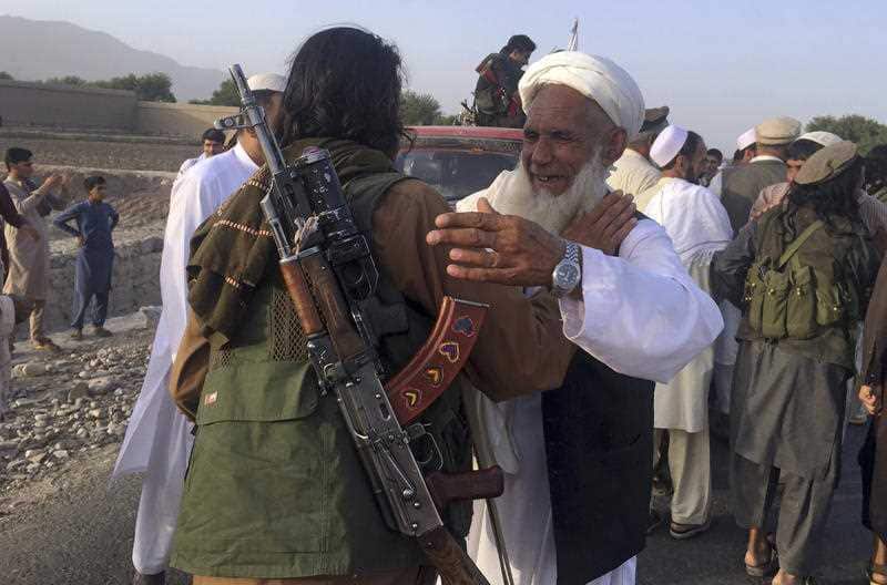 In this June 16, 2018 file photo, Taliban fighters gather with residents to celebrate a three-day cease fire marking the Islamic holiday of Eid al-Fitr.