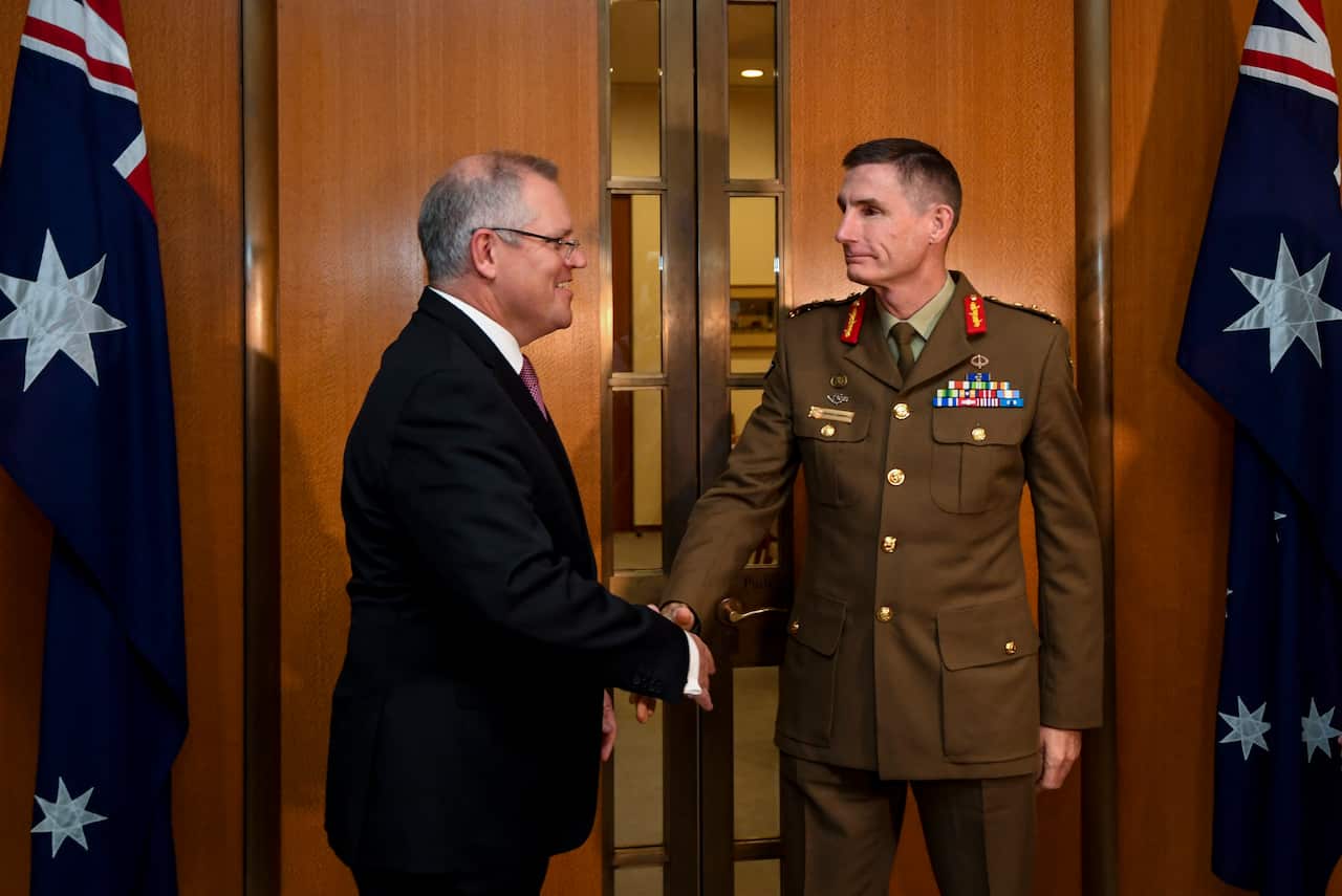 Chief of the Australian Defence Force (CDF) General Angus Campbell (right) shakes hands with Australian Prime Minister Scott Morrison.