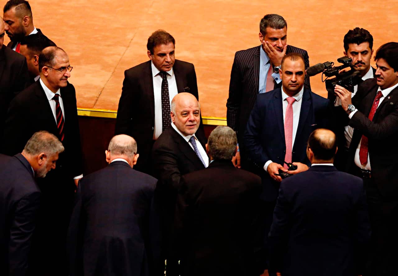 Iraq Prime Minister Haider al-Abadi, center, arrives at the parliament building to attend the first session in Baghdad, Iraq.