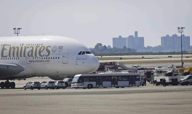 Emergency response crews gather outside a plane at New York's Kennedy Airport amid reports of ill passengers aboard a flight from Dubai, Wednesday Sept. 5, 2018.