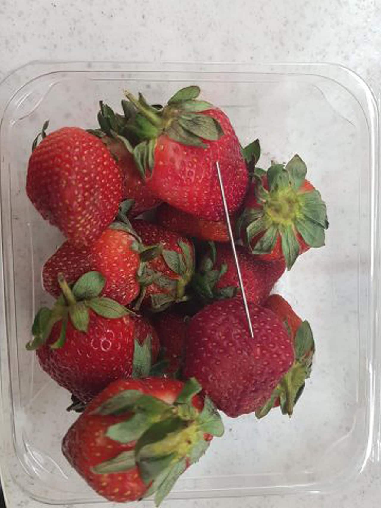 In this supplied undated image obtained in September 2018, a thin piece of metal is seen among a punnet of strawberries. 