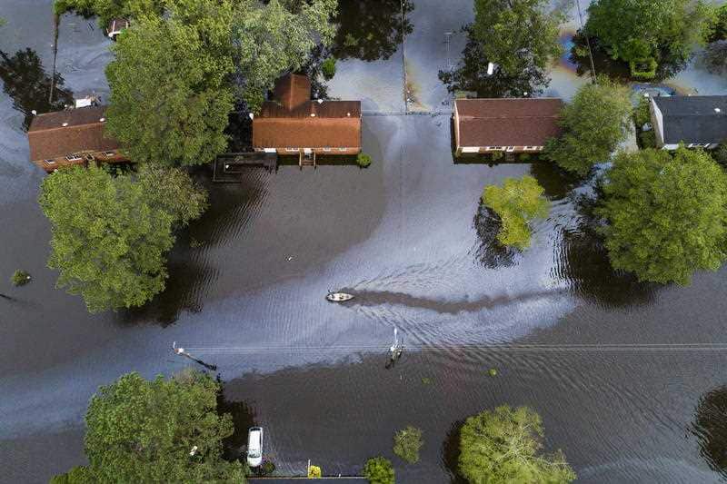 Two people in a canoe paddle through a street that was flooded by Hurricane Florence north of New Bern, North Carolina USA.