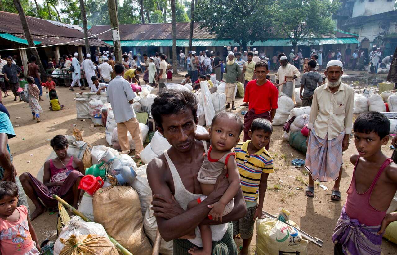 In this Monday, Oct. 2, 2017, file photo, newly arrived Rohingya Muslims from Myanmar prepare to leave a transit shelter in Shahparirdwip, Bangladesh. 