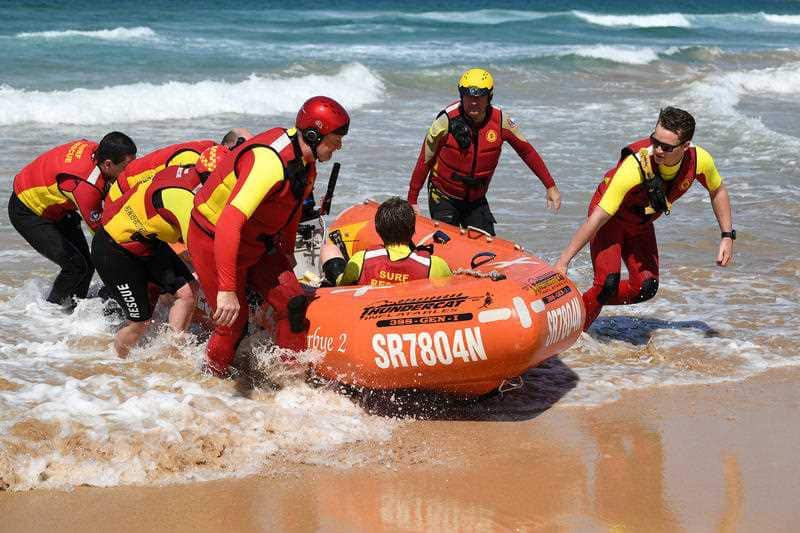 Volunteer Surf Life savers perform a rescue drill at the Surf Life Saving season launch at Manly Beach in Sydney 