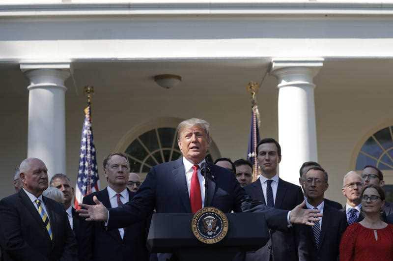President Donald Trump, center, gestures as he announces a revamped North American free trade deal, in the Rose Garden of the White House in Washington, Monday, Oct. 1, 2018. 