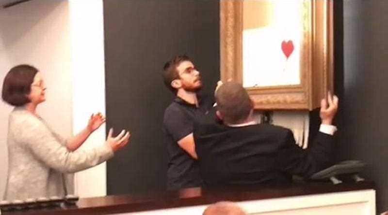 A video posted on Banky's instagram account shows the street artist's artwork, Girl With Balloon, being taken away after shredding itself.