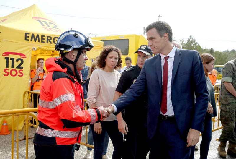 Spanish Prime Minister Pedro Sanchez greets a response worker, the day after heavy rains and flash flooding hit Mallorca