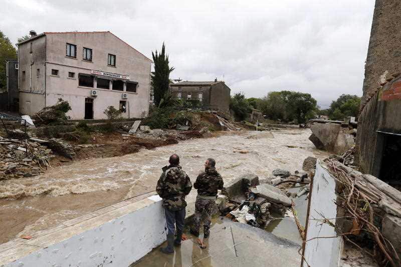 Men looks at scenery of damaged houses in Villegailhenc, France.