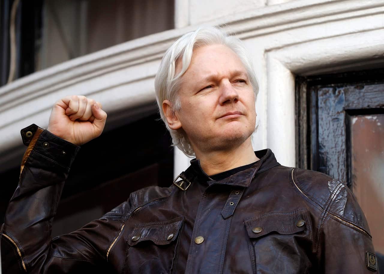 Julian Assange greets supporters outside the Ecuadorian embassy in London.