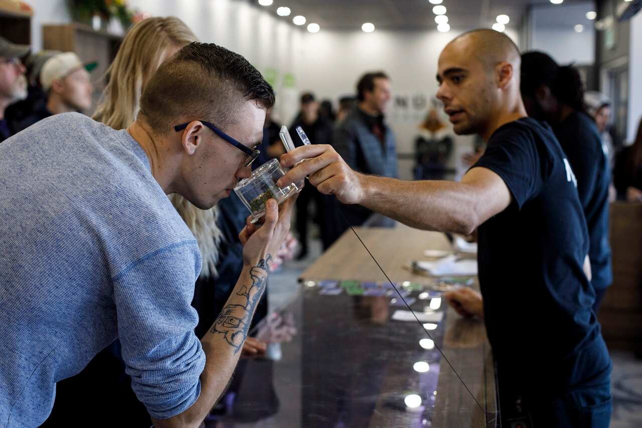 Kyle Bell of Numo Cannabis helps a customer decide on his purchase of legal marijuana in Edmonton, Alberta.