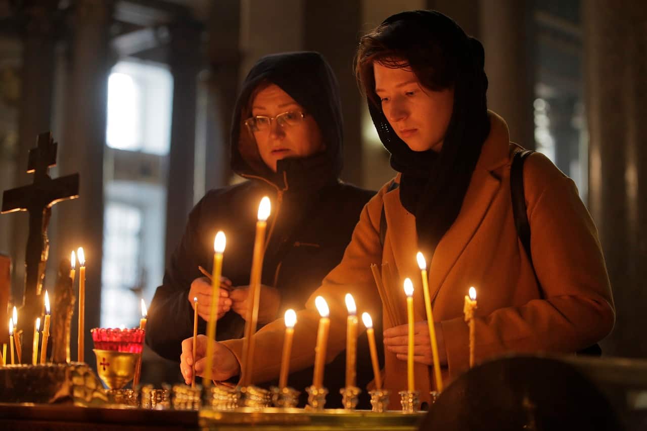 Women light candles in memory of the victims in a church in St.Petersburg, Russia.