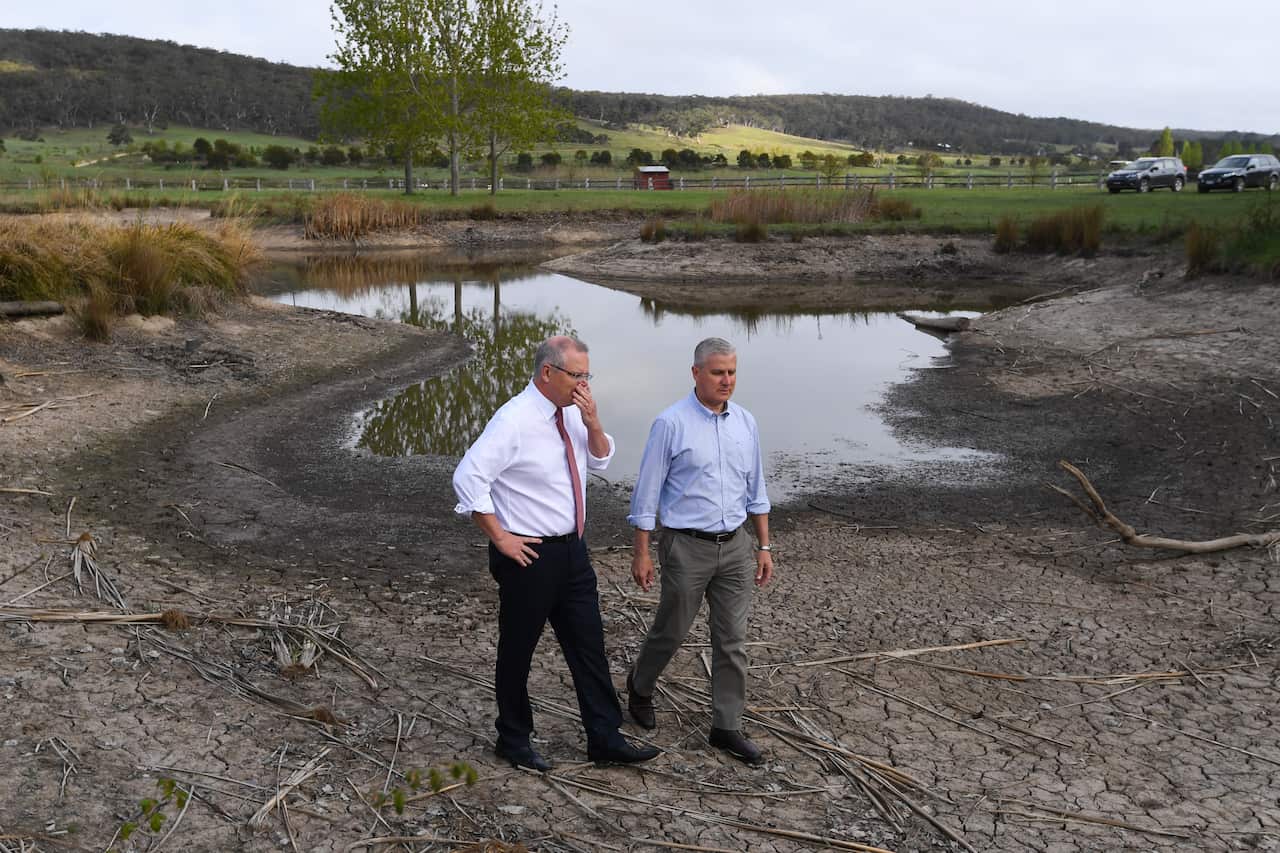 Prime Minister Scott Morrison and Deputy Prime Minister Michael McCormack walk along a dry damn during a visit to Mulloon Creek Natural Farm near Bungendore.