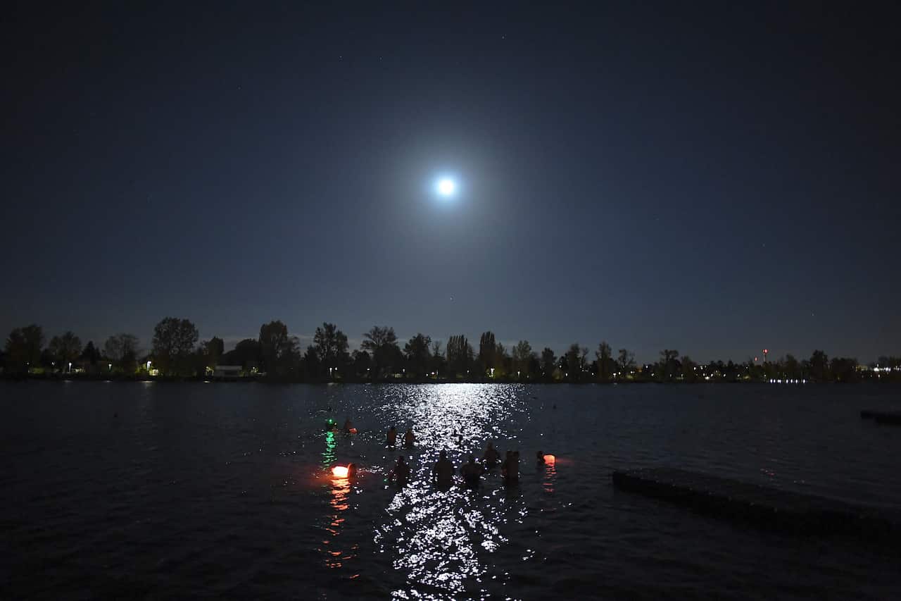 People take a swim in the 11,3 degree Celsius (52,3 Fahrenheit) water of the New Danube Channel, during a full moon in Vienna, Austria, 24 October 2018.  EPA/CHRISTIAN BRUNA