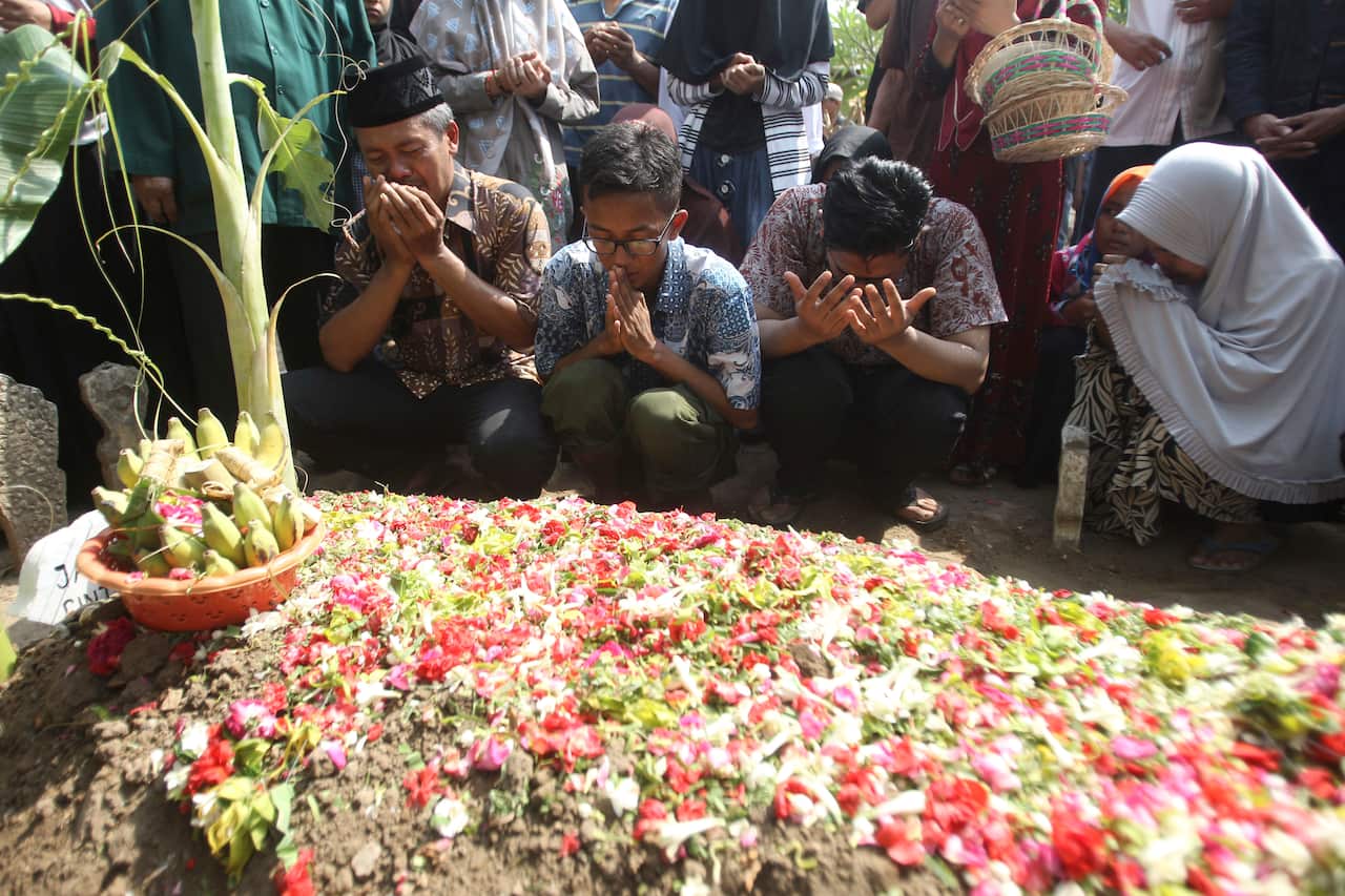 Family members pray at the gravesite of one of the victims of the Lion Air crash. 