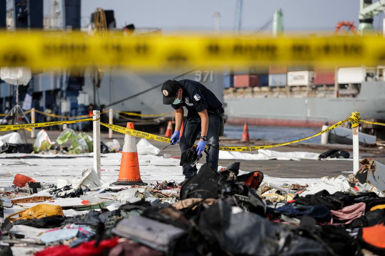 An Indonesian forensic police officer takes samples from recovered belongings of the passangers of the crashed Lion Air flight JT610 last year. 