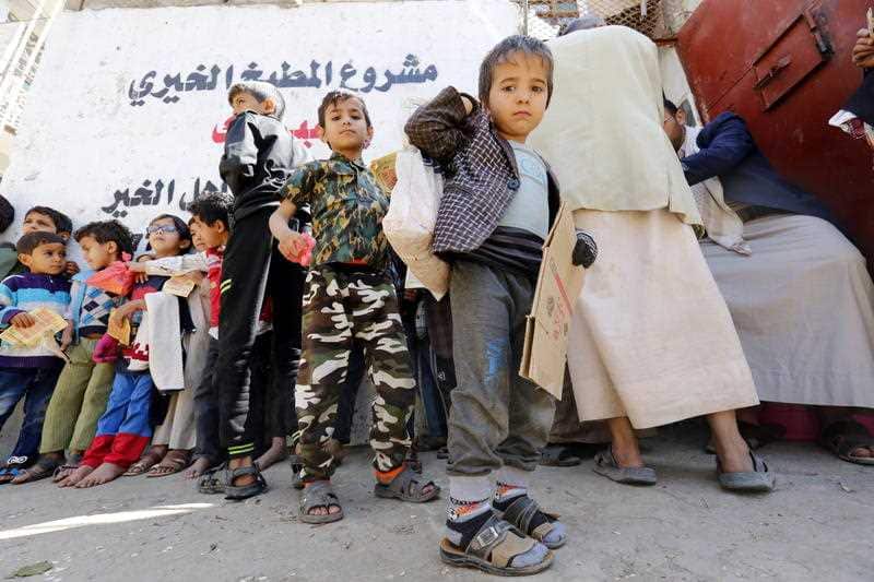 Conflict-affected children wait to receive their families' free food rations from a local charity in Sana'a, Yemen.