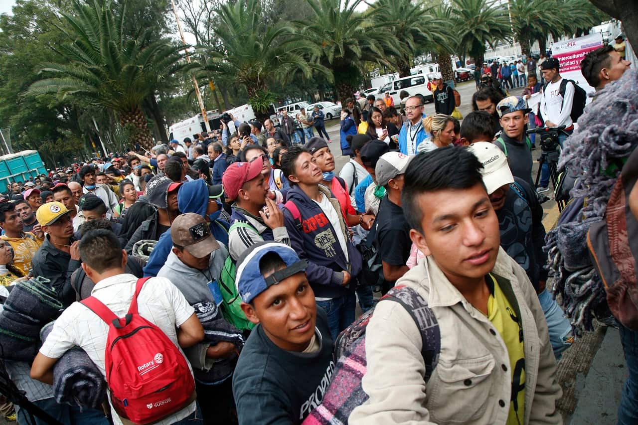 Central American migrants file into a sporting centre that has been turned into a shelter for them in Mexico City.