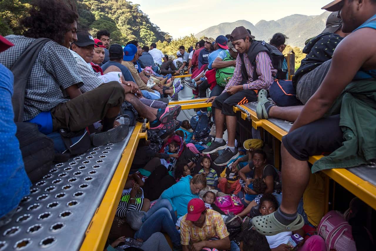 Central American migrants begin their morning trek with a free ride on a truck.